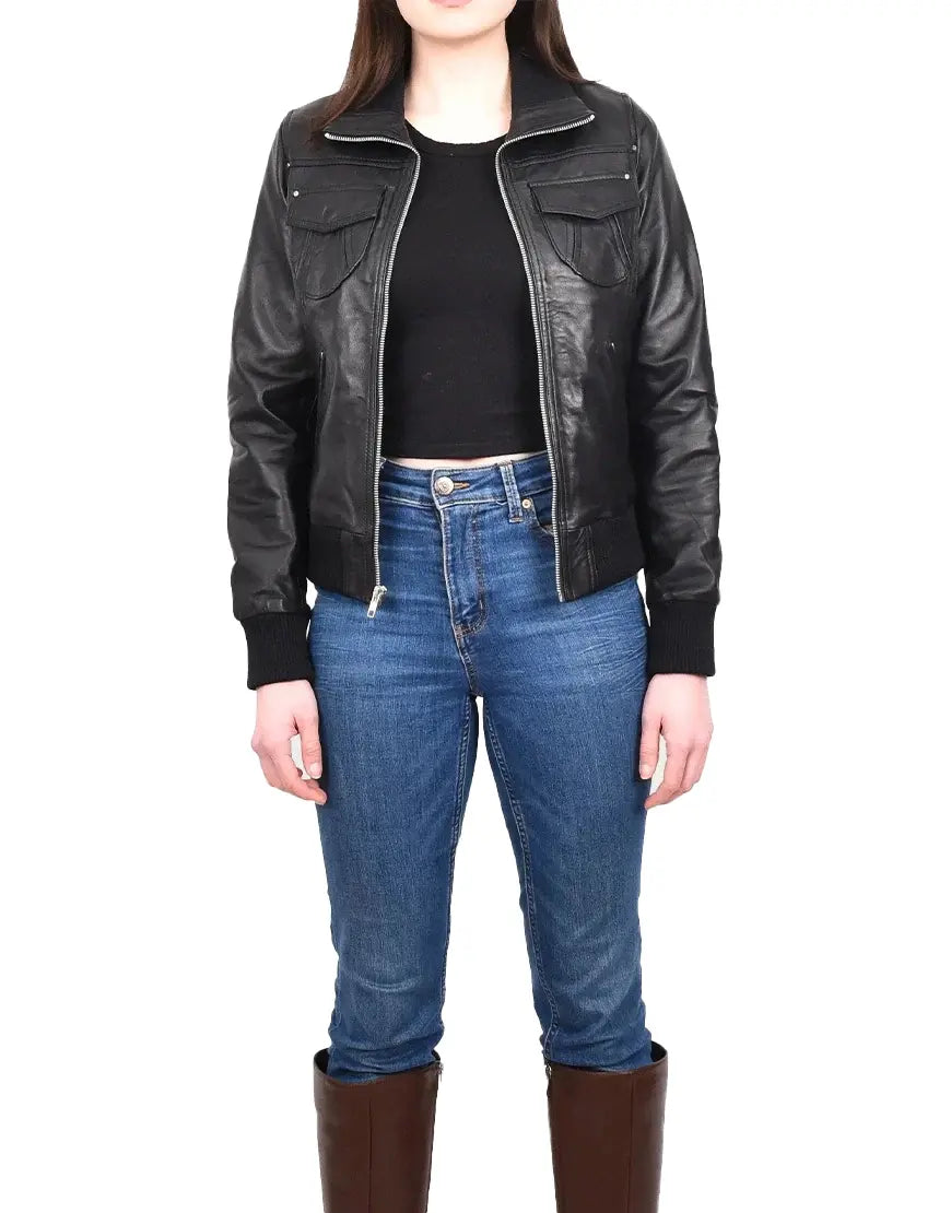 Person wearing a black leather jacket, black top, blue jeans, and brown boots